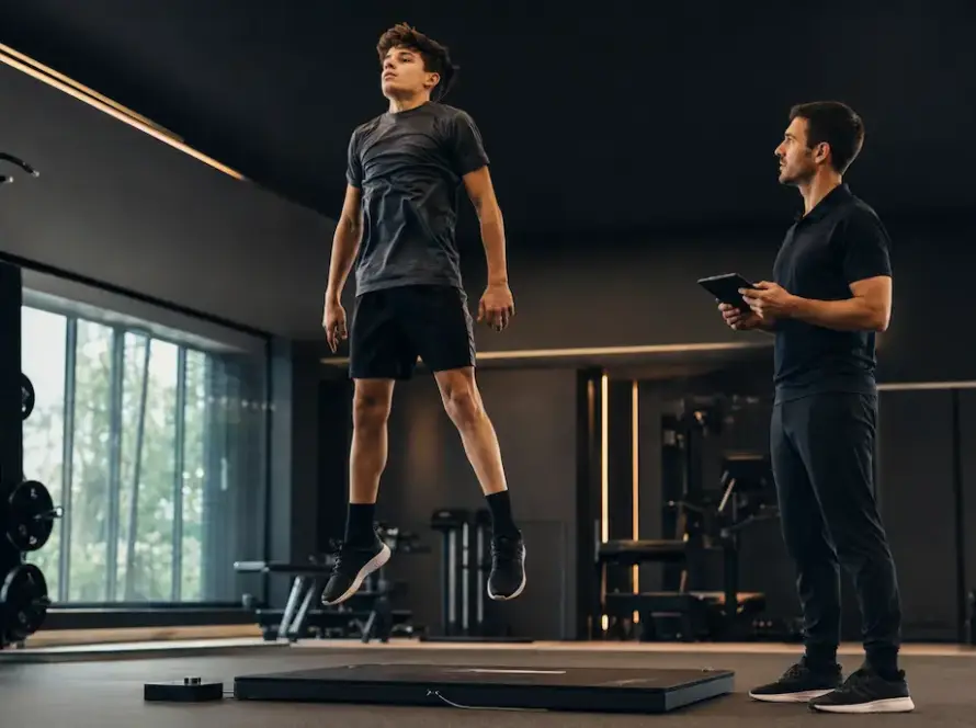 Giovane atleta durante una valutazione di potenza in Performance Lab con coach che registra i dati.